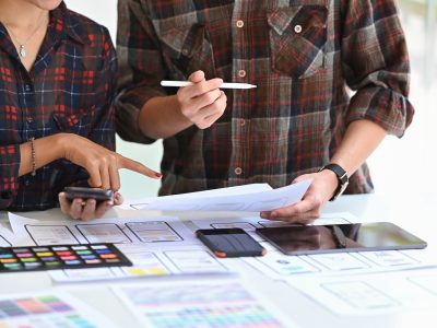 Team of UX designer designing a wireframe application of mobile phone and responsive website.